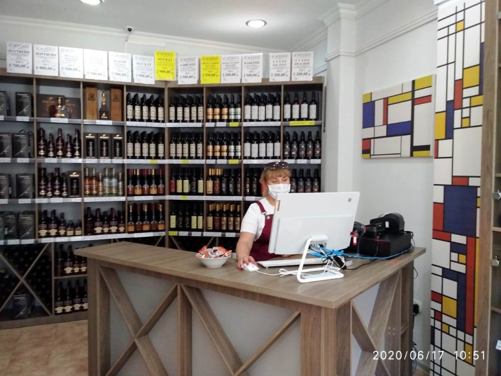 на фото изображен продавец в фирменном магазине Завода марочных вин Коктебель